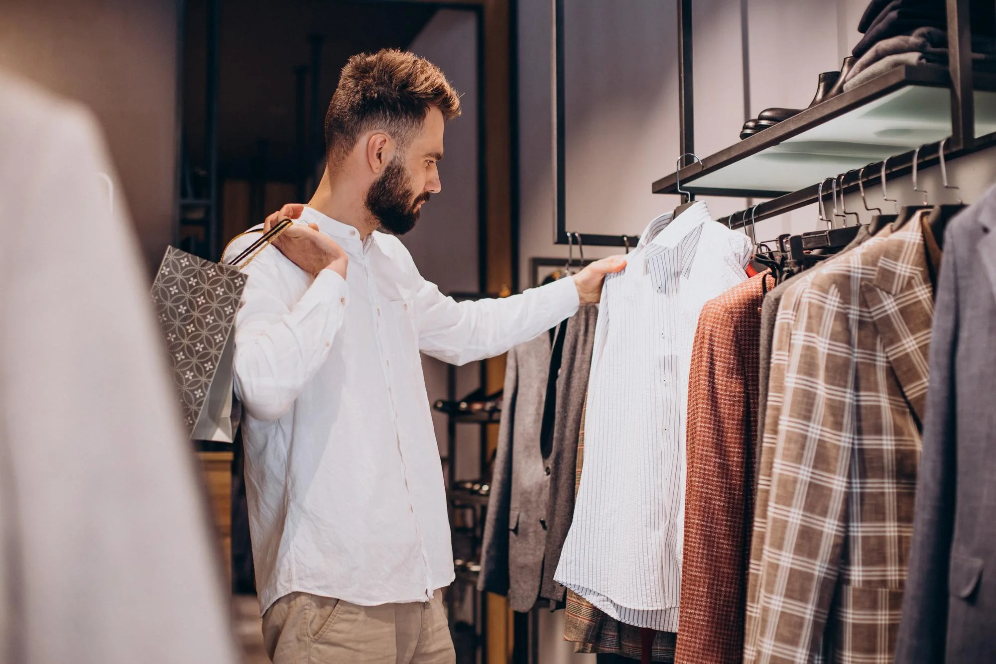 Man staat voor een kledingkast en bekijkt de kleding.